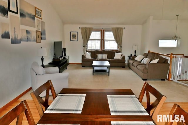 carpeted dining area featuring vaulted ceiling and baseboards