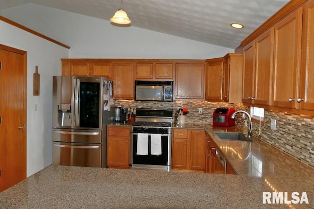 kitchen with brown cabinets, stainless steel appliances, lofted ceiling, and a sink