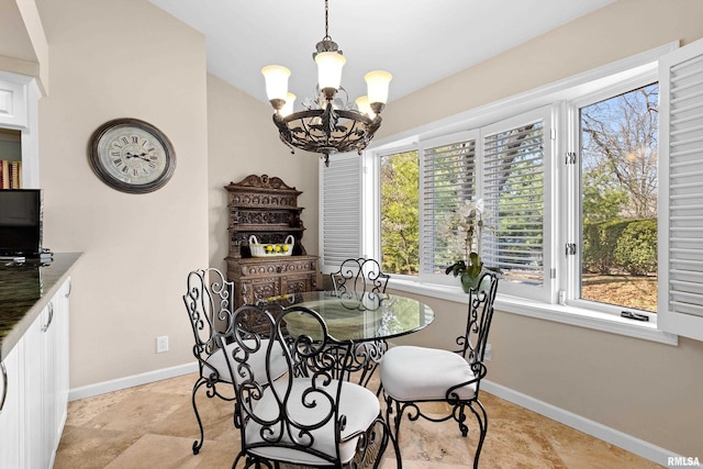 dining space featuring baseboards, an inviting chandelier, and vaulted ceiling