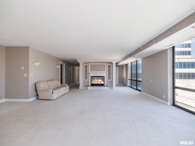 unfurnished living room featuring a glass covered fireplace, visible vents, baseboards, and light carpet