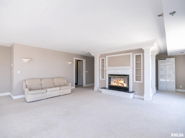 unfurnished living room featuring decorative columns, baseboards, carpet, and a fireplace