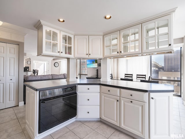 kitchen with oven, recessed lighting, white cabinets, light tile patterned floors, and glass insert cabinets