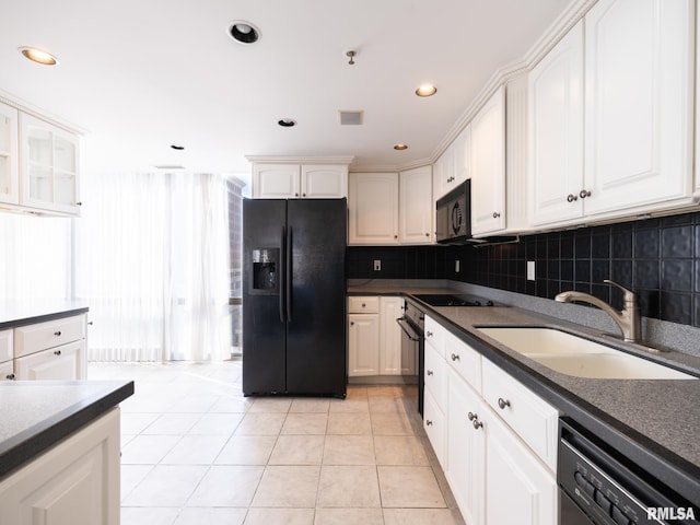 kitchen featuring black appliances, dark countertops, tasteful backsplash, and a sink