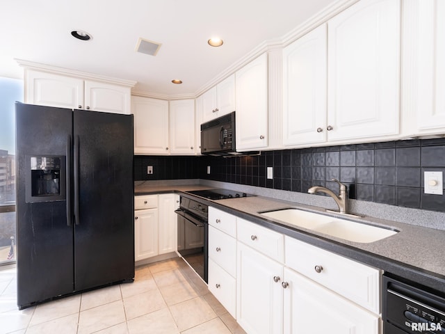 kitchen featuring light tile patterned floors, a sink, decorative backsplash, black appliances, and white cabinetry