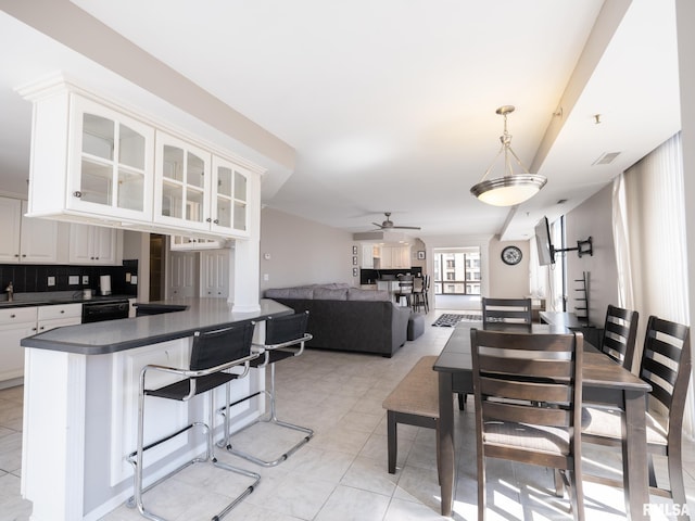 dining area featuring light tile patterned floors, visible vents, stairway, and a ceiling fan