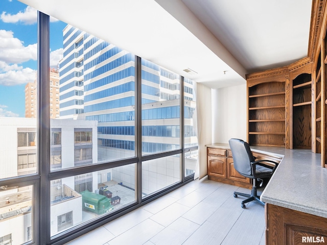 unfurnished office with a wall of windows and built in study area