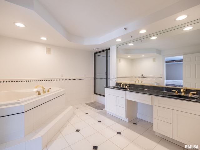 bathroom with double vanity, recessed lighting, a sink, tile patterned flooring, and a bath