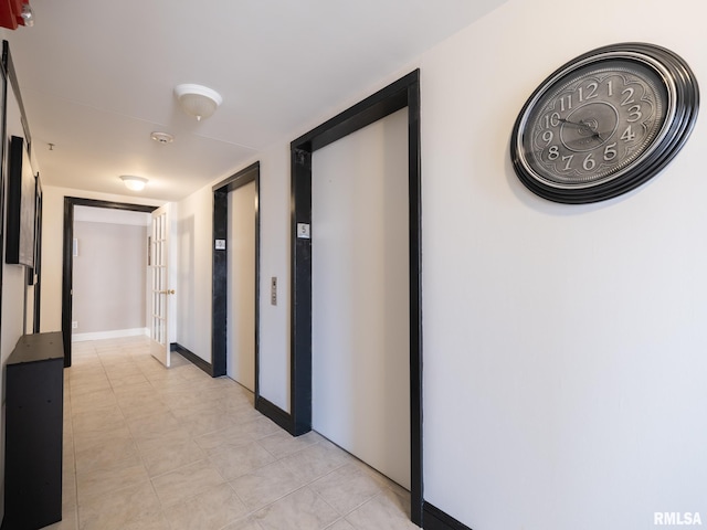 corridor with elevator and baseboards