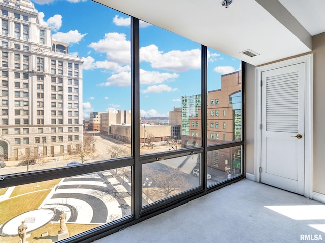 unfurnished sunroom featuring a city view and visible vents