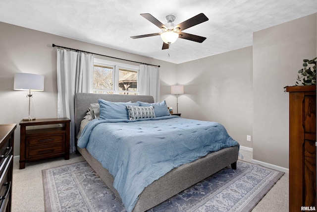 bedroom with light colored carpet, baseboards, and ceiling fan