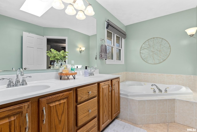 full bathroom featuring a bath, tile patterned floors, a skylight, and a sink