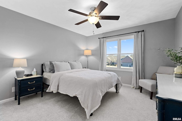 bedroom featuring a ceiling fan, light colored carpet, and baseboards