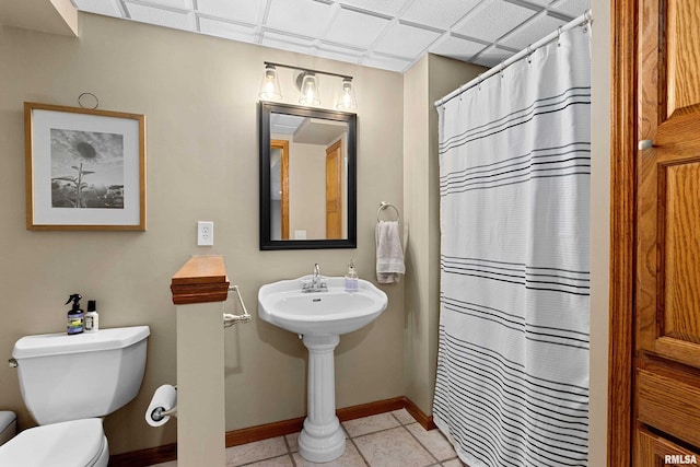 bathroom with tile patterned floors, a shower with curtain, baseboards, and toilet