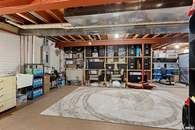 unfinished basement with electric panel and brick wall