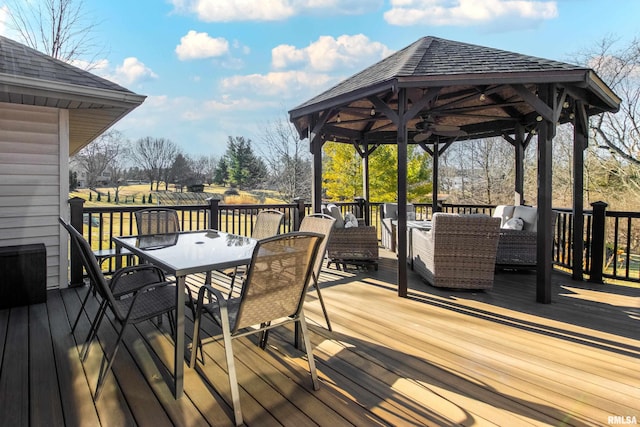 wooden terrace with outdoor dining space, a gazebo, and an outdoor living space