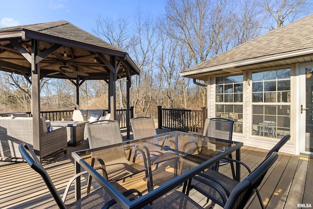 wooden terrace featuring a gazebo, outdoor dining area, ceiling fan, and outdoor lounge area