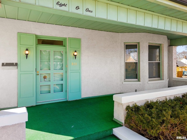 entrance to property featuring board and batten siding and stucco siding