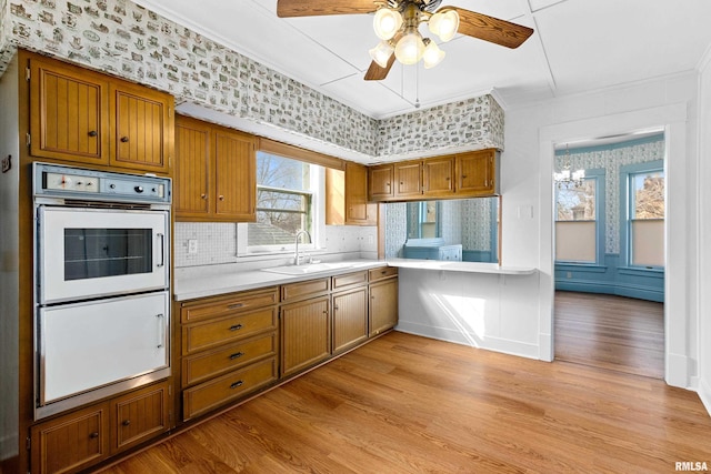 kitchen with a sink, brown cabinetry, and light countertops