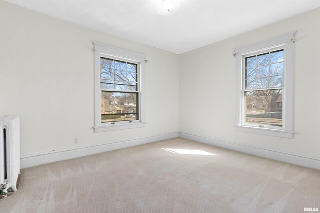 unfurnished room featuring radiator heating unit, baseboards, and carpet floors