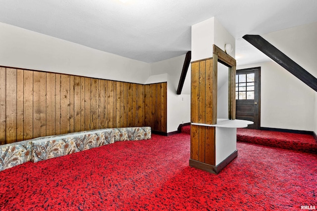 bonus room with wooden walls and carpet floors