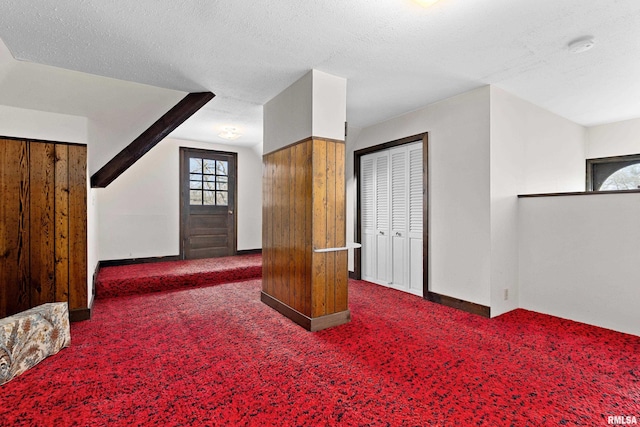 bonus room featuring a textured ceiling, baseboards, and carpet floors