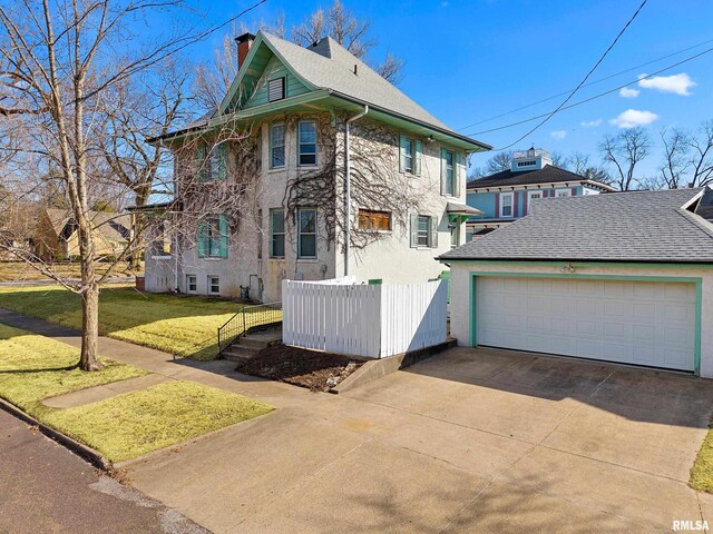 view of front facade featuring fence, concrete driveway, a front yard, stucco siding, and a chimney