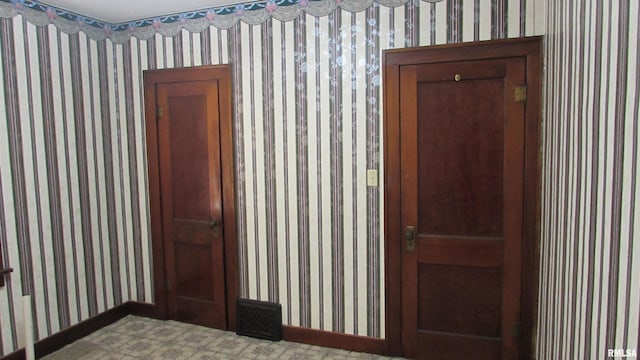 spare room with baseboards and wallpapered walls