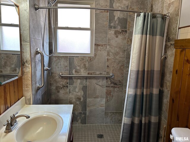 full bath with a stall shower and vanity