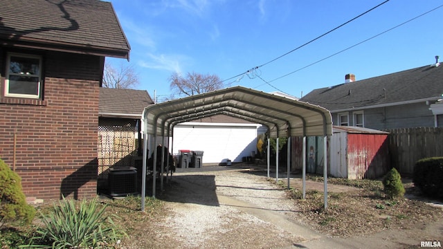 view of parking with a detached carport and fence