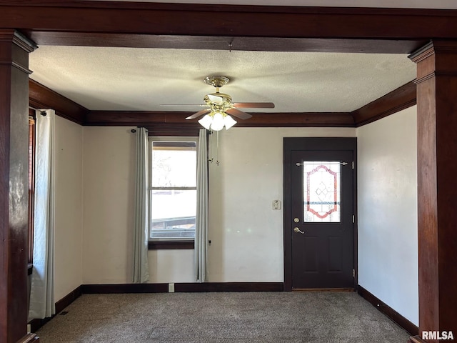 foyer with ornamental molding, a ceiling fan, a textured ceiling, carpet, and baseboards