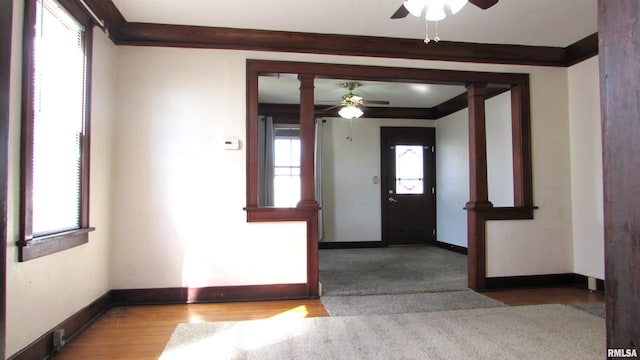 spare room featuring wood finished floors, a ceiling fan, baseboards, and ornamental molding