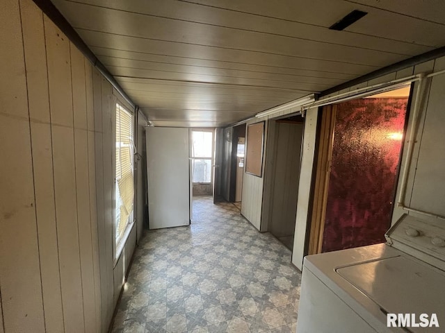 interior space featuring wooden walls, washer / clothes dryer, wood ceiling, and light floors