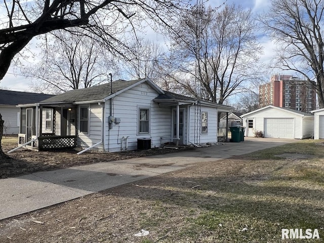 view of front of home with a detached garage, central AC unit, and an outdoor structure