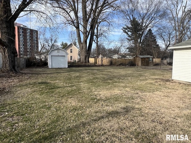 view of yard featuring a storage shed, an outdoor structure, and fence