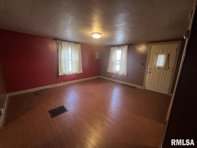 foyer entrance with wood finished floors, visible vents, and baseboards