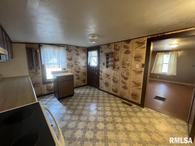 interior space with visible vents, baseboards, light floors, and electric stove