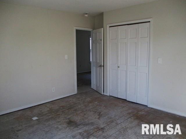 unfurnished bedroom with a closet and baseboards