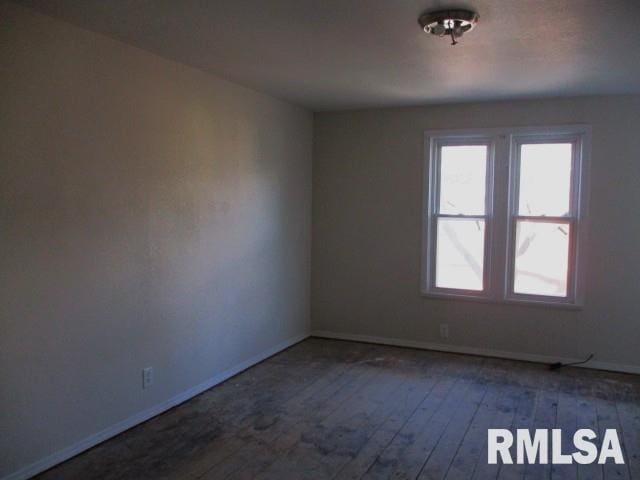 empty room with baseboards and hardwood / wood-style flooring