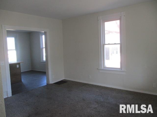 carpeted empty room featuring baseboards