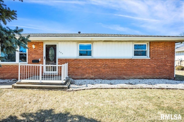 ranch-style house featuring brick siding and a front lawn