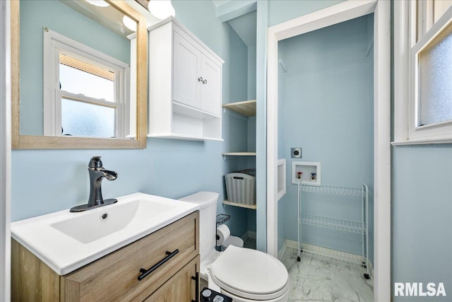 bathroom with toilet, marble finish floor, and vanity