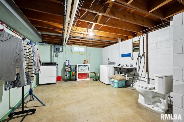 unfinished below grade area featuring a sink, electric panel, and washer / dryer