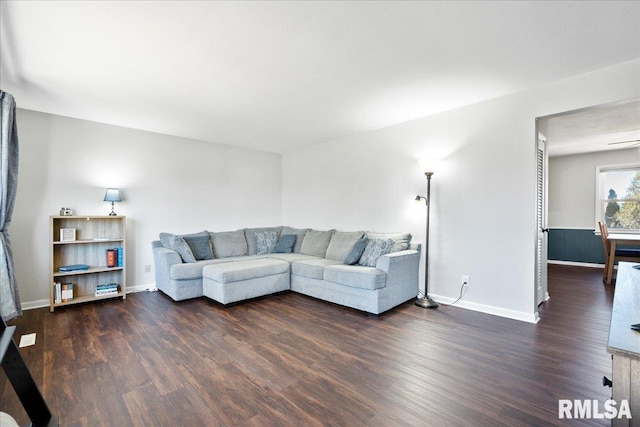 living area with dark wood-type flooring and baseboards