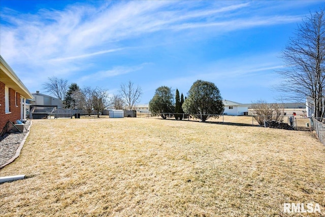 view of yard featuring an outbuilding and fence