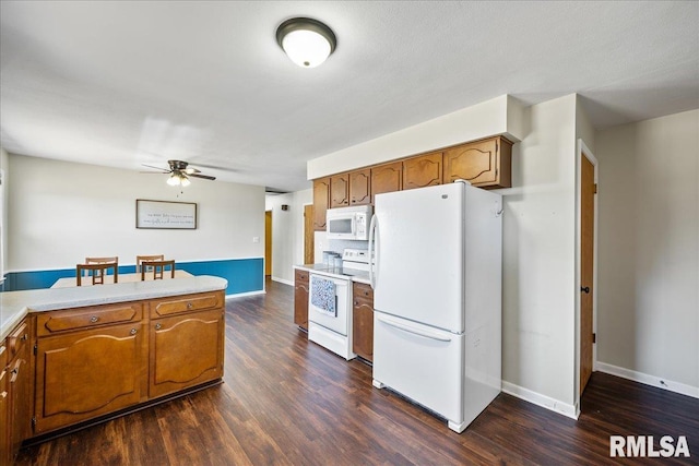 kitchen featuring brown cabinetry, white appliances, and dark wood-style flooring