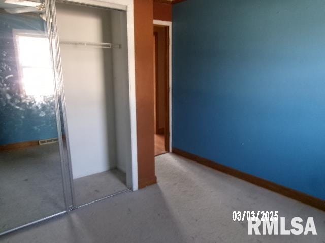 unfurnished bedroom with a closet and baseboards