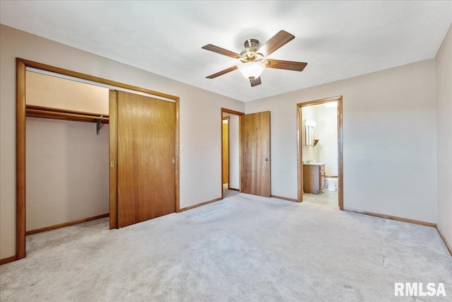 unfurnished bedroom featuring ceiling fan, baseboards, light carpet, ensuite bathroom, and a closet