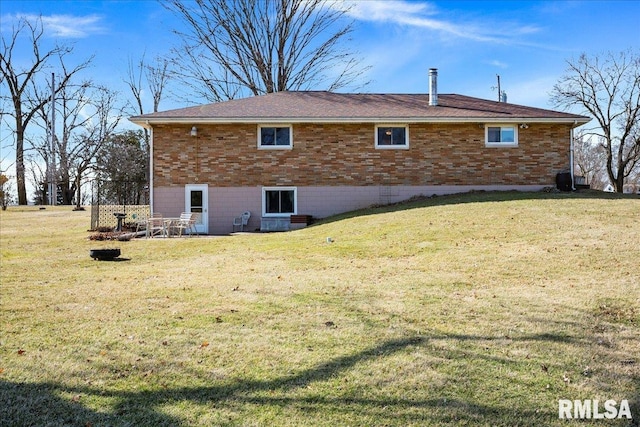 view of side of home featuring brick siding and a yard