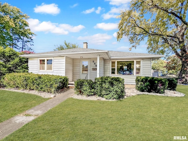 view of front of property with a front yard and a shingled roof