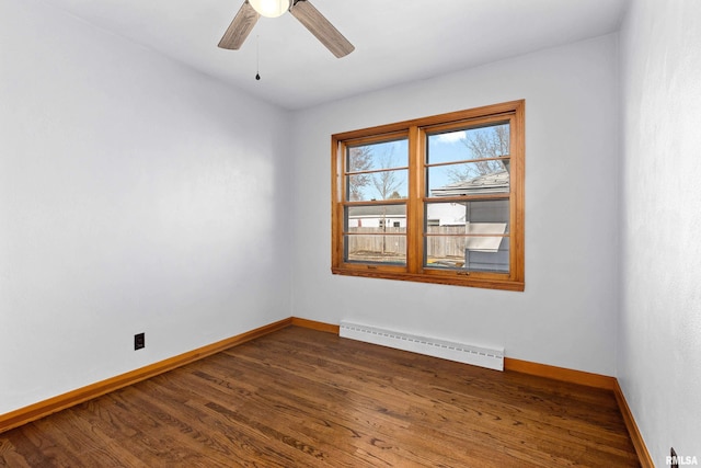 empty room with a baseboard heating unit, baseboards, dark wood-type flooring, and ceiling fan